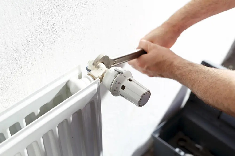Chauffagiste spécialiste Saunier Duval intervenant sur un radiateur de chauffage